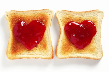 Beyaz arka planda çilek reçelli iki tost.