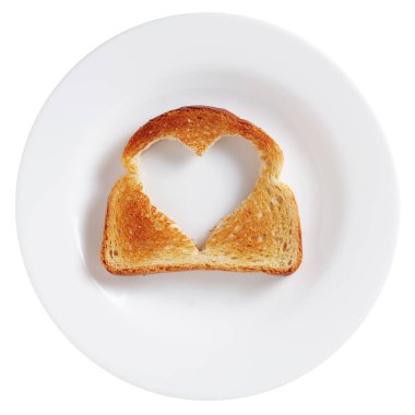 Tabakta kalp şeklinde bir kesikle dilimlenmiş ekmek dilimi. Beyaz arkaplan, üst görünüm