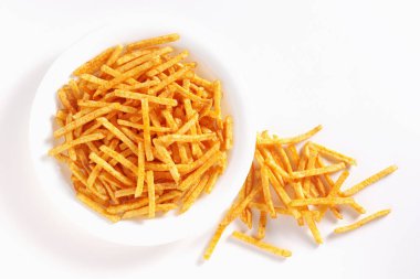Beyaz arka planda tabakta tuzlu patates çubukları, üst manzara.