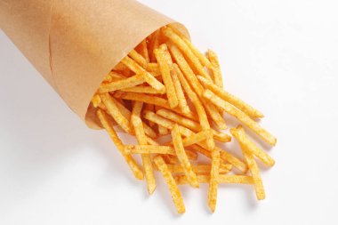 Beyaz arka planda, kağıt torba içinde çıtır tuzlu patates çubukları.