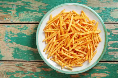 Eski yeşil ahşap zemin üzerinde tuzlu patates çubukları, fotokopi alanı ile üst manzara