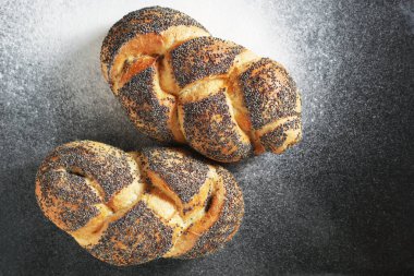 Üzerinde un olan siyah tepside haşhaşlı çörekler.