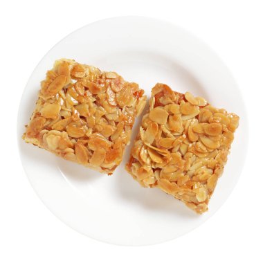 Beyaz arkaplanda izole edilmiş bir tabakta bademli pasta, üst görünüm