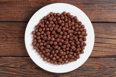 Tahta arka planda bir tabakta çikolatalı mısır topları, üst manzara. Sağlıklı kahvaltı.