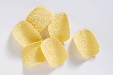 Beyaz arka planda leziz patates cipsi, üst manzara. Bira için iyi atıştırmalık