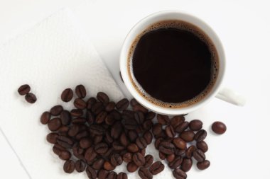 Bir fincan kahve ve fasulyenin hemen üstünde.