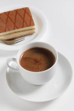 Bir fincan kahve ve Süngerli kek kiraz ve kremalı kokteyl beyaz arka planda