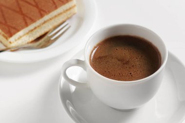 Bir fincan kahve ve Süngerli kek kiraz ve kremalı kokteyl beyaz arka planda