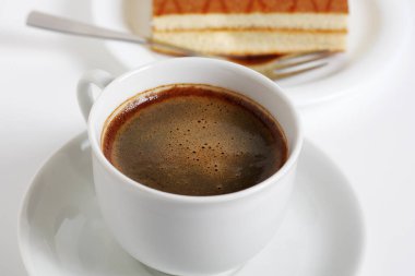 Bir fincan kahve ve Sponge kek vişneli ve kremalı kokteyl. Beyaz arka planda.