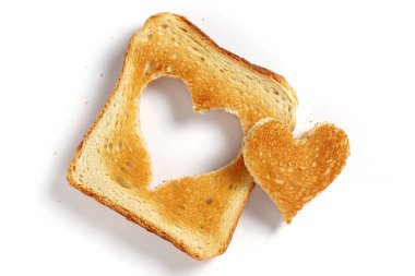 Beyaz arka planda kalp şeklinde kesilmiş ekmek, üst manzara.