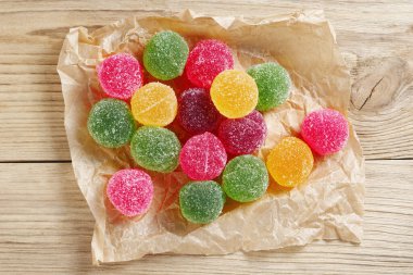 Marmelat şeker topları eski ahşap arka planda buruşuk kağıt üzerinde, üst manzara