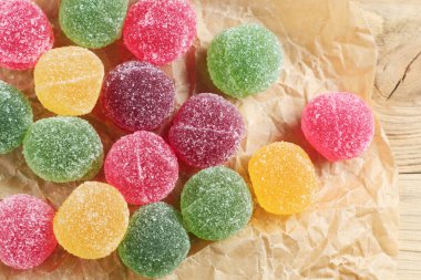 Marmelat şeker topları eski ahşap arka planda buruşuk kağıt üzerinde, üst manzara