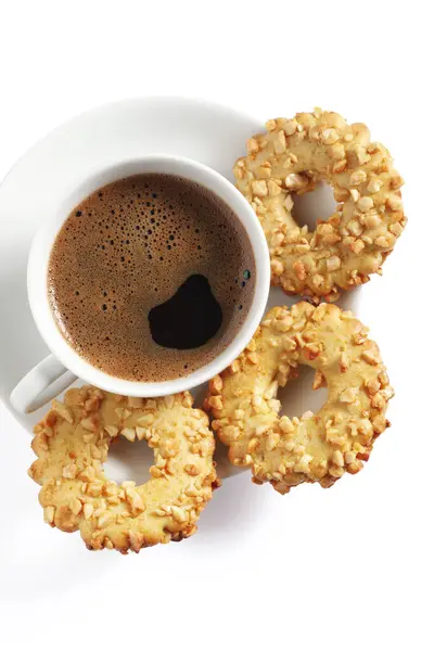Cup of coffee and cookies rings with nuts on a white background, top view