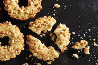 Kırık kurabiye halkası. Arka planda yer fıstığı var. Üst tarafta.