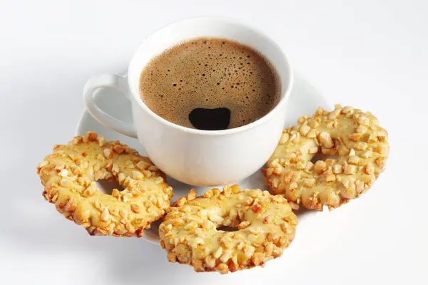 Cup of coffee and cookies rings with nuts on a white background
