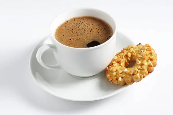 Cup of coffee and cookie rings with nuts on a white background
