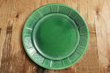 Eski ahşap zemin üzerinde boş temiz yeşil tabak, üst görünüm