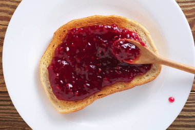 Eski ahşap zemin üzerinde reçelli ekmek dilimi, üst manzara