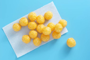 Mavi arka planda peynir aromalı mısır topları, üst görünüm