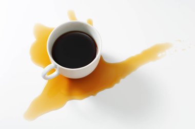 Beyaz masaya dökülen bir fincan kahvenin tam üstünde. Kavramsal fotoğraf