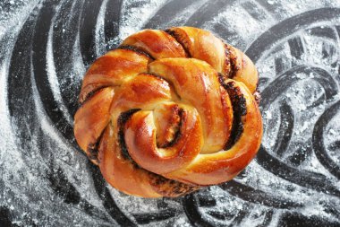 Üzerinde un serpiştirilmiş siyah tepside çikolatalı çörek.