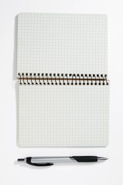 Beyaz zemin üzerinde kalem olan sarmal defter, üst görünüm