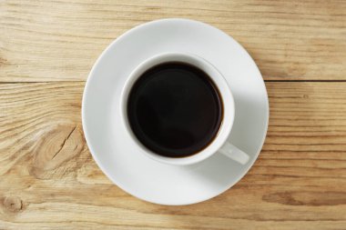 Eski ahşap arka planda bir fincan sade kahve.