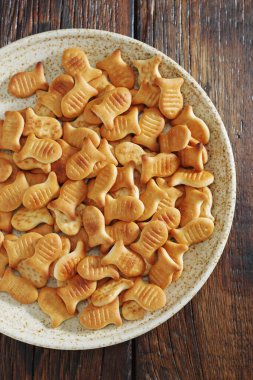 Tabakta balık şeklinde krakerler, ahşap masa, üst manzara.