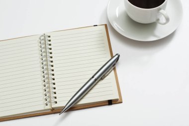 Beyaz arkaplanda boş bir defter, kalem ve kahve aç.