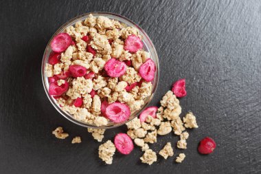 Siyah taş arka planda cam kasede kızartılmış yaban mersini.