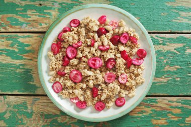 Eski yeşil ahşap arka planda, tabakta kızartılmış yaban mersini.