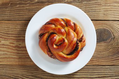 Eski ahşap arka planda bir tabakta çikolatalı çörek.