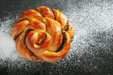 Üzerinde un serpiştirilmiş siyah tepside çikolatalı çörek.