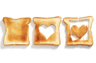 Beyaz arka planda kalp şeklinde kesilmiş ekmek, üst manzara.