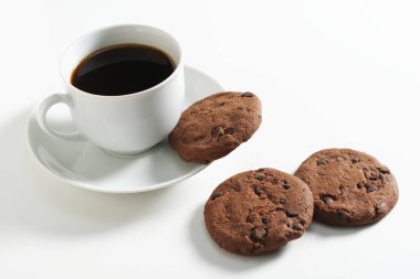 Beyaz arka planda bir fincan kahve ve çikolatalı kurabiye.