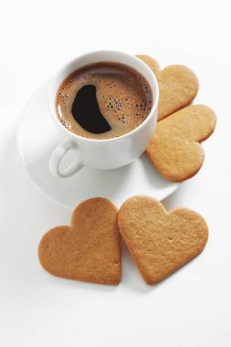 Beyaz arka planda kahve ve kalp şeklinde zencefilli kurabiye.