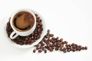 Beyaz arka planda bir fincan kahve ve fasulye. Metin için boşluk