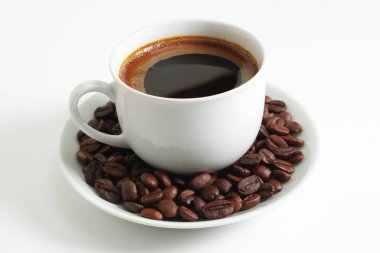 Beyaz arka planda bir fincan kahve ve fasulye yakın plan