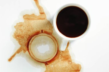 Beyaz arka planda bir fincan kahve ve lekeler, üst manzara. Kavramsal fotoğraf