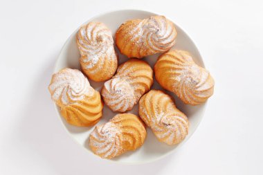 Beyaz arkaplanda tabağı dolduran kurabiyeler, üst görünüm