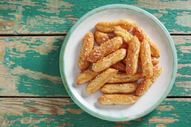 Eski yeşil ahşap zemin üzerinde şekerli poğaça kurabiyeleri, fotokopi alanı ile üst görünüm