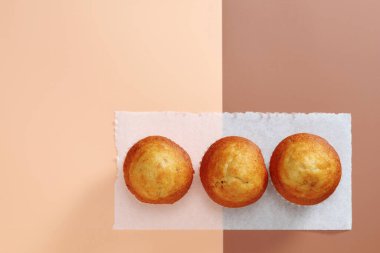 İki tonluk arka planda mini kekler, fotokopi alanı ile üst görünüm