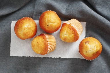 Gri kumaş arka planda küçük kekler, üst görünüm