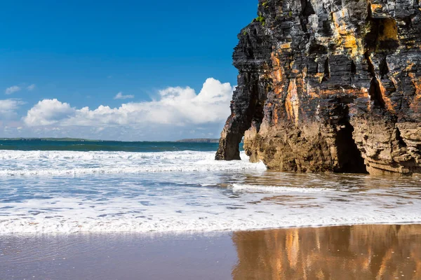 アイルランドのケリー州バリブニオンビーチの湿った砂の中に反射する海の波と絵のような崖 野生の大西洋の道の発見ポイントの1つ — ストック写真