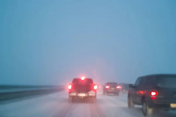 在恶劣的天气条件下开车 夜间高速公路上下着雪 长时间暴露在摄像机中 模糊了方向 — 图库照片
