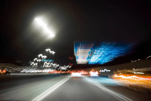 Autos Schilder Und Lichter Auf Der Nächtlichen Stadtautobahn Bewegungsunschärfe Durch lizenzfreie Stockbilder