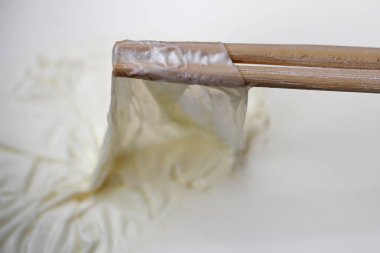 Sütün yüzeyindeki süt kabuğunu ahşap sopalarla temizleyin.