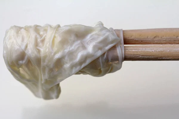 牛乳の表面から乳の皮を木の棒で取り除き — ストック写真