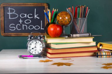 Okul malzemeleri hafif arka planda bir kompozisyonda sergilenir. Okula geri dön..