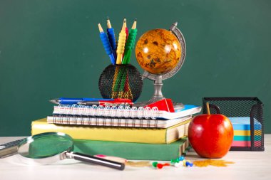 Okul malzemeleri hafif arka planda bir kompozisyonda sergilenir. Okula geri dön..